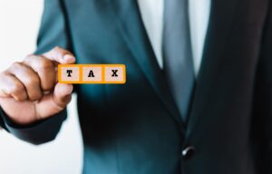 business-man-holding-tax-text-sign-for-present