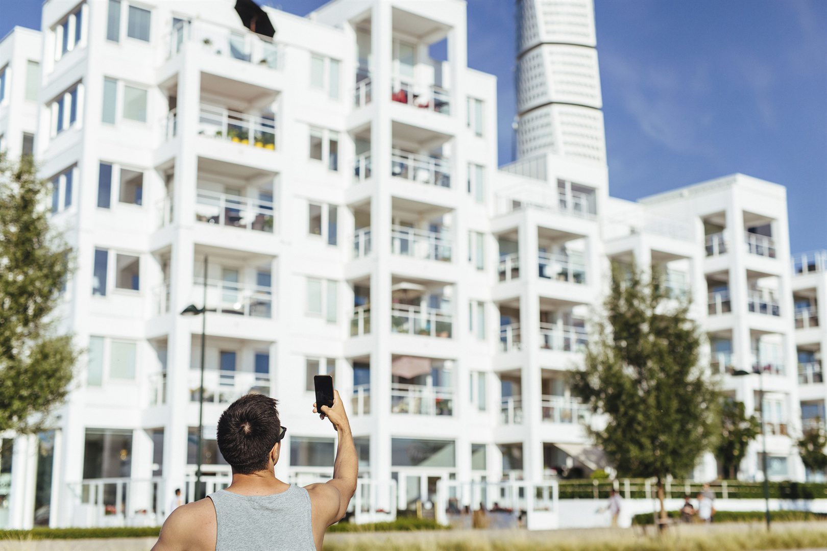 rear-view-of-man-photographing-apartment-building